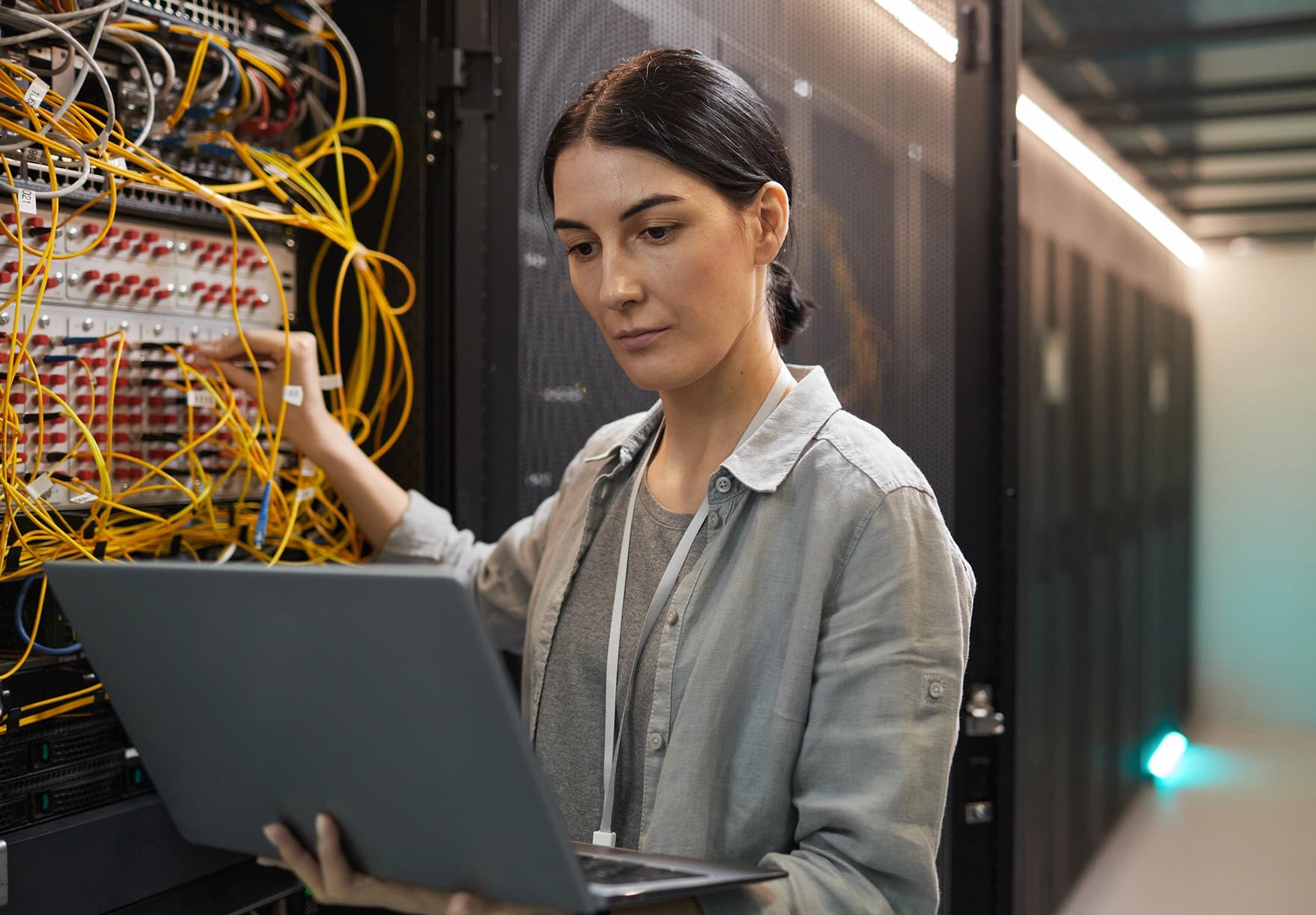 A woman with a laptop working on a server.png