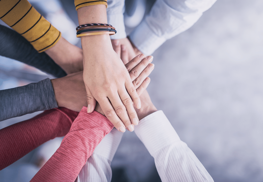 A group of people putting their hands together