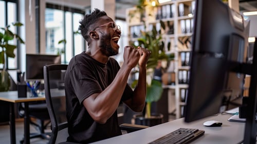 Employee celebrating success at work after receiving a bonus or achieving a performance milestone.