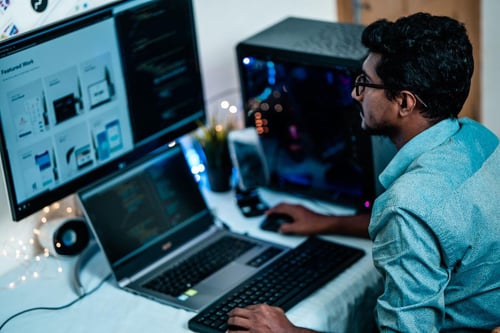 man working with a laptop and monitor