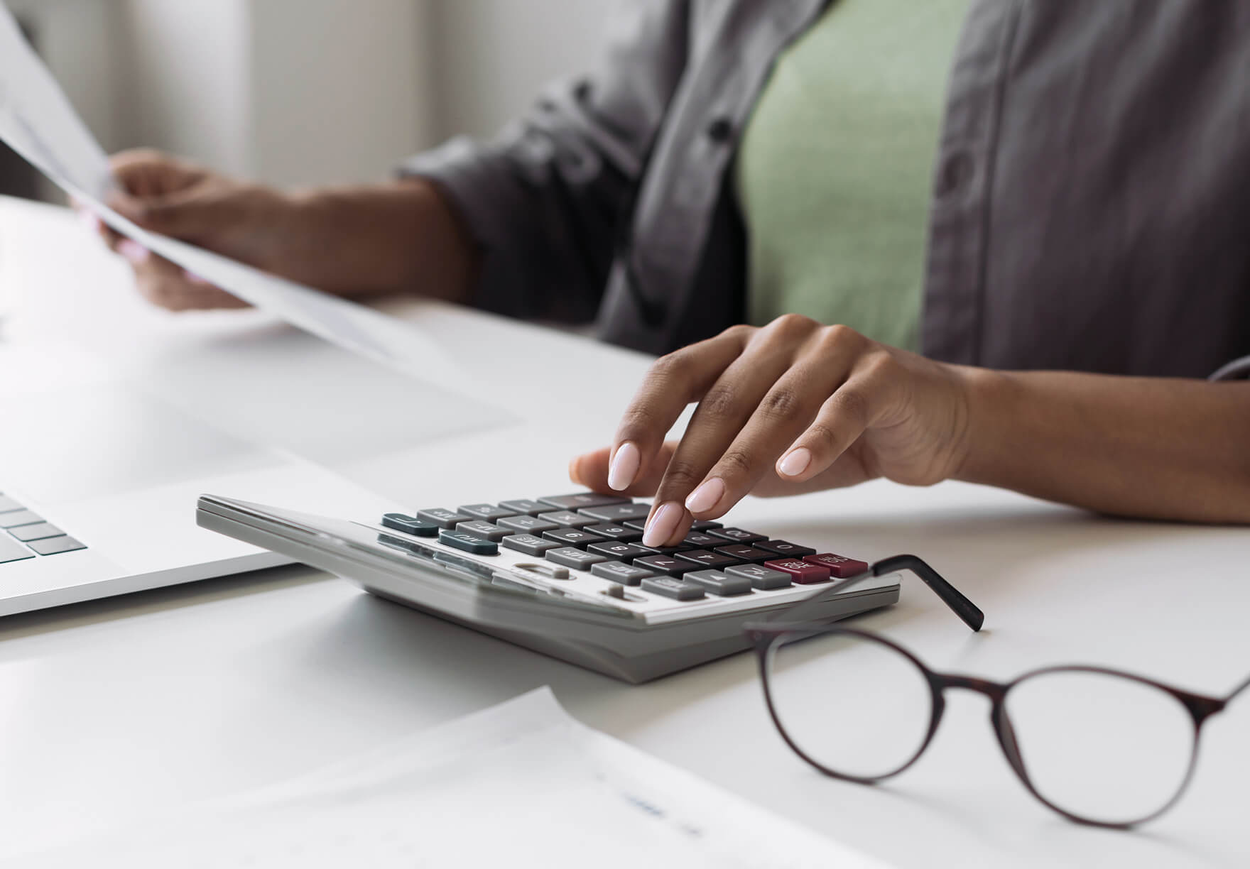 A person working with a calculator to crunch the number on international hiring