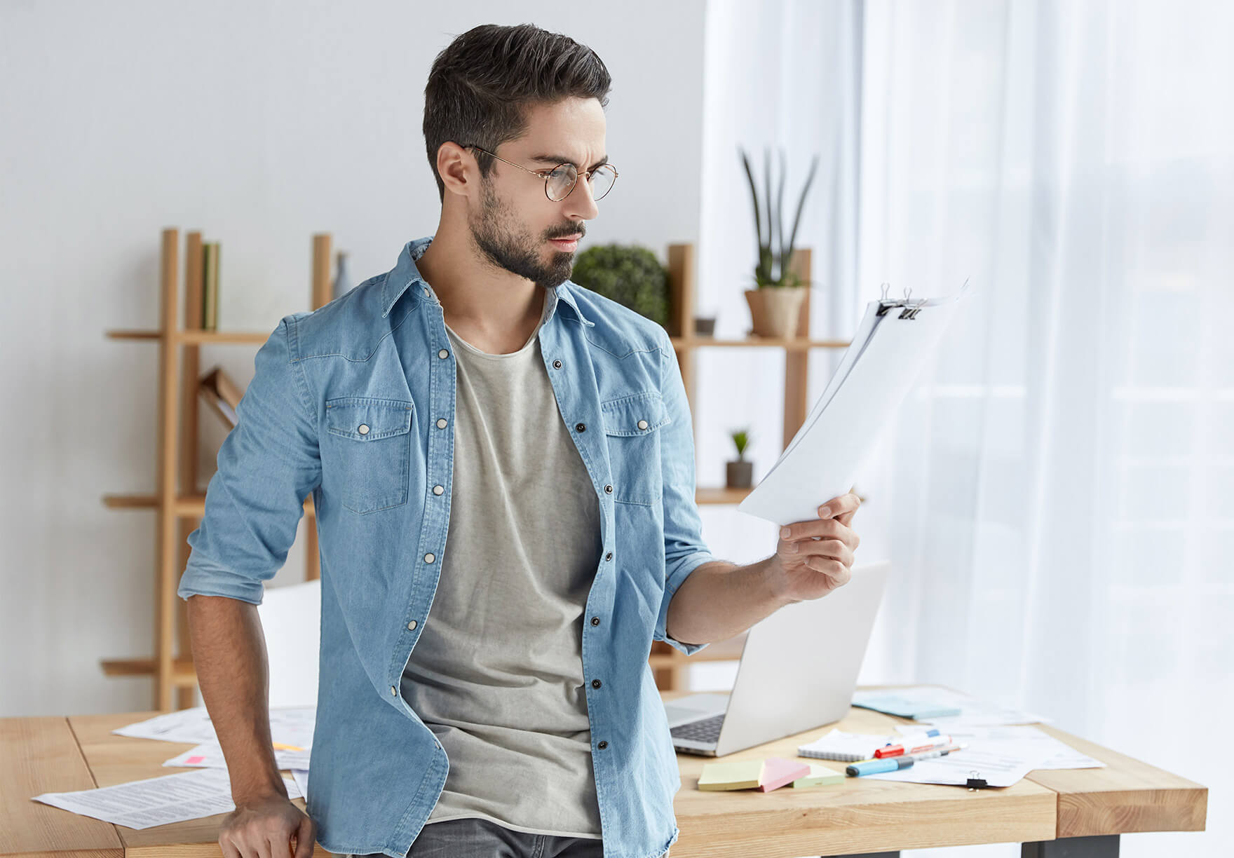 Man in blue jacket reading a piece of paper