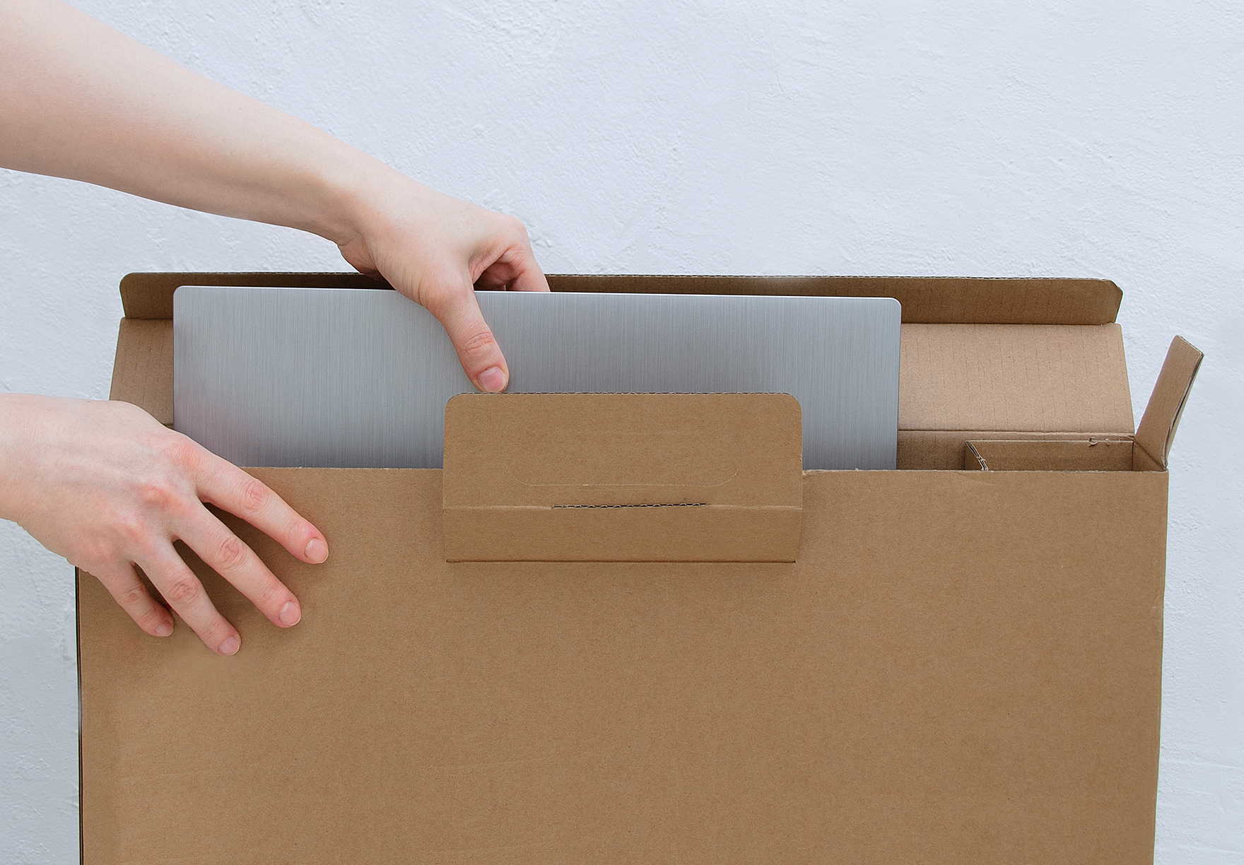 Relocating remote worker pulling a laptop from a packing box