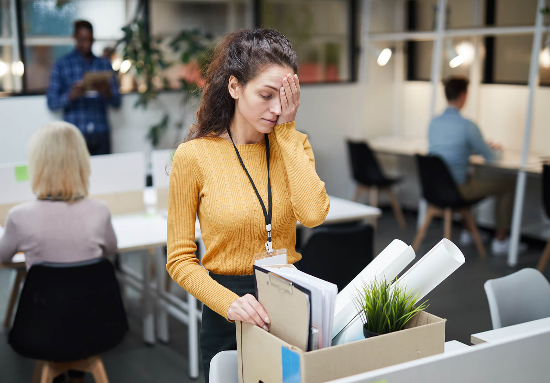 Woman in a pink sweater looking unhappy in an office