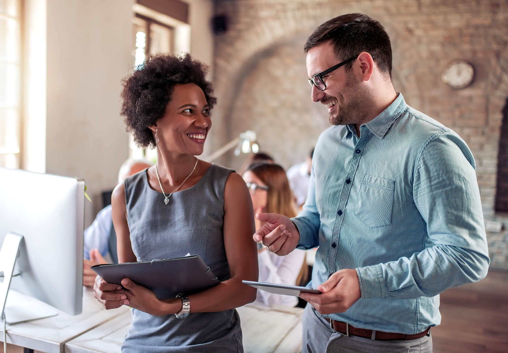 a man and woman laughing as they discuss their notes