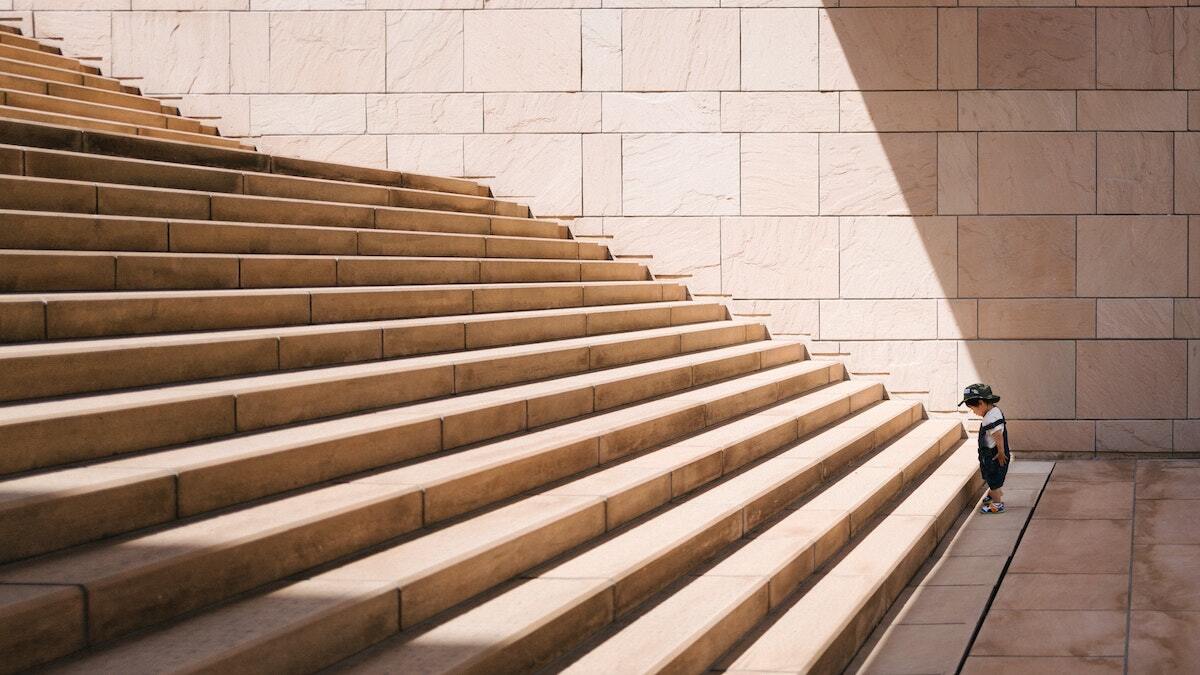 toddler standing at the bottom of a staircase