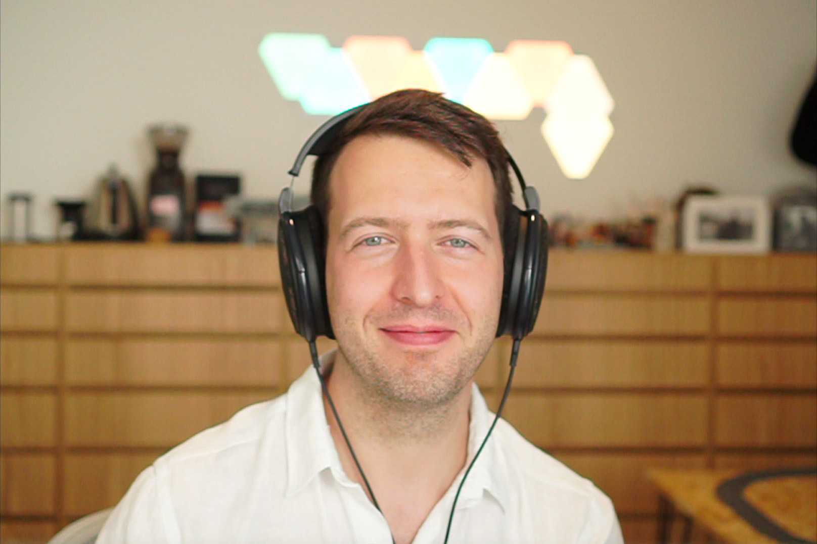 Job in a white shirt wearing black headphones